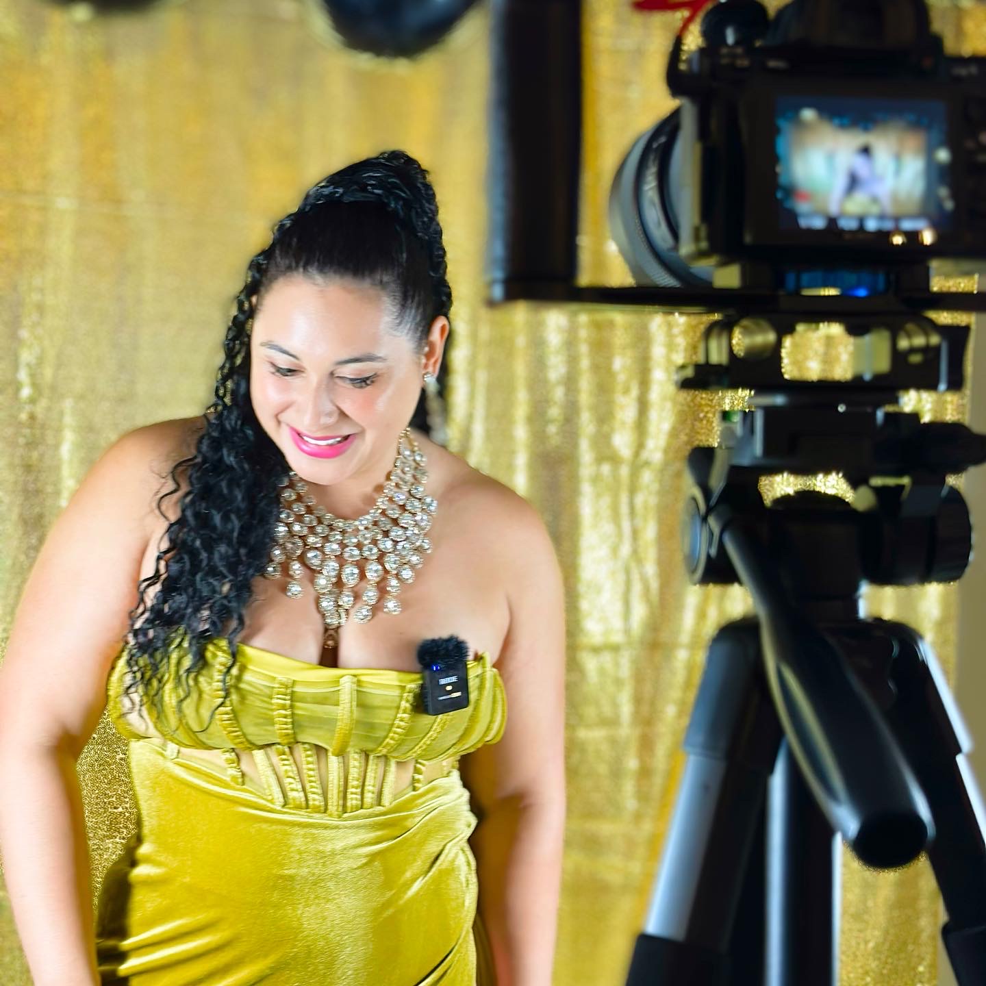 Angelica Robles behind the scenes at a gold-backdrop photoshoot